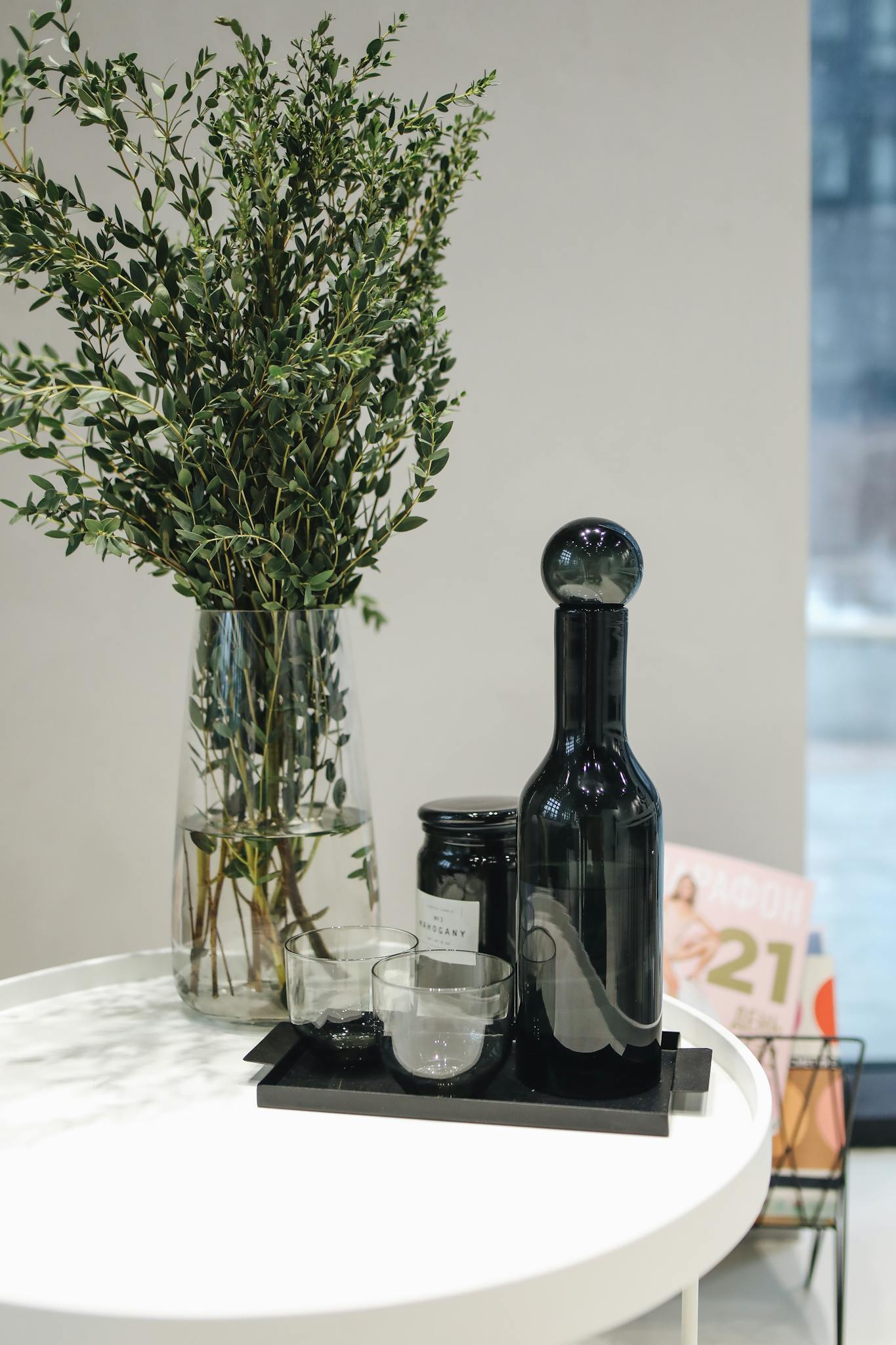 Sophisticated glass bottles and greenery on a stylish table, perfect for luxury interiors.